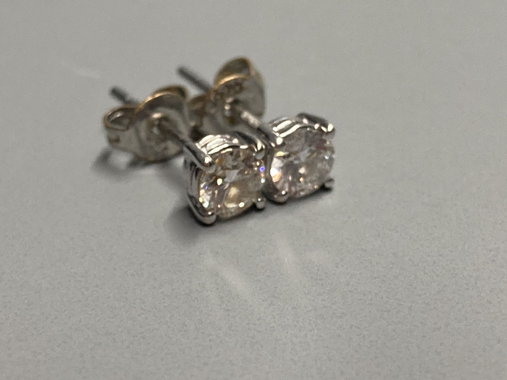 A modern pair of 18ct white gold and solitaire diamond set ear studs, gross 1 gram.